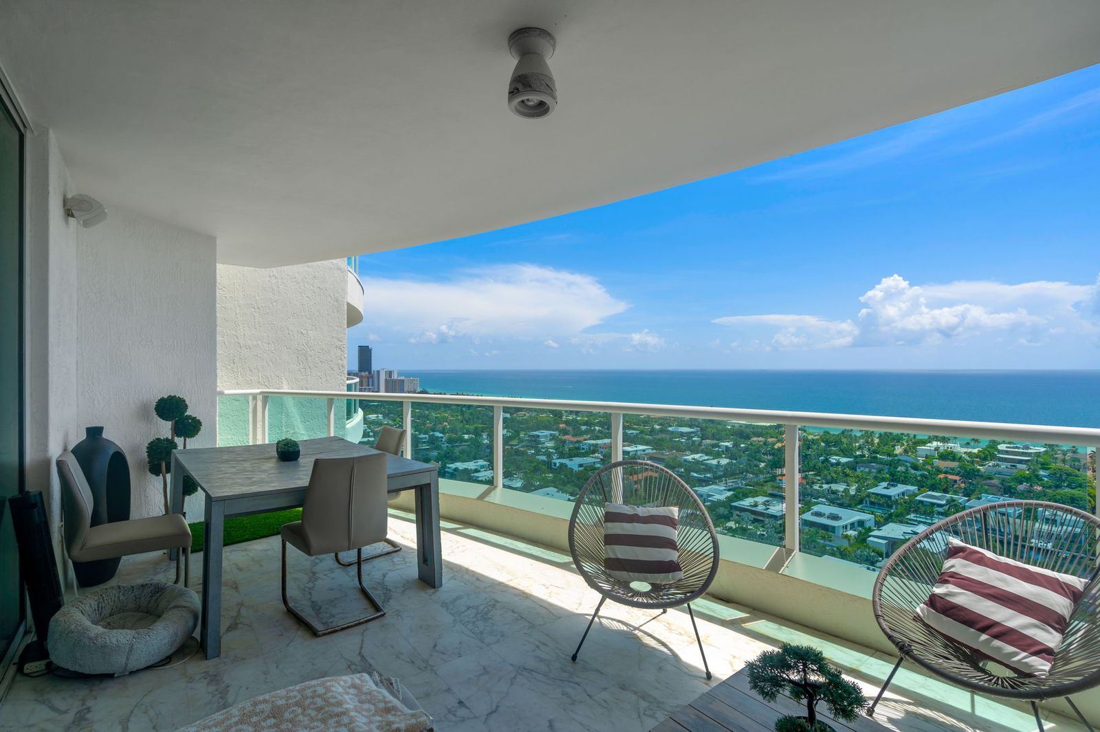 Curved glass balcony with ocean and skyline views
